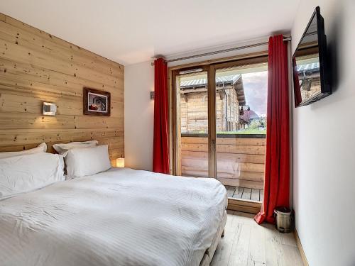 une chambre avec un lit blanc et une fenêtre dans l'établissement Le K2 1- appartement- 6pers -proche pistes, aux Gets