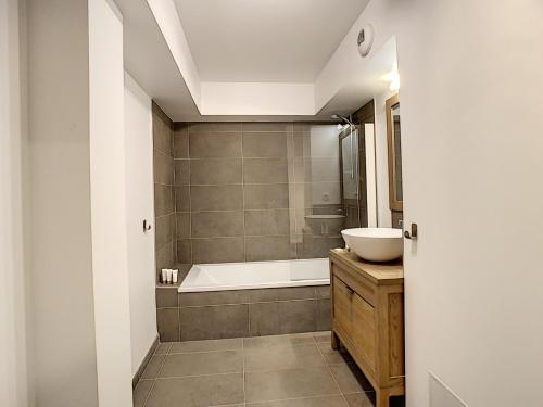 une salle de bain avec une baignoire et un lavabo dans l'établissement Le K2 1- appartement- 6pers -proche pistes, aux Gets