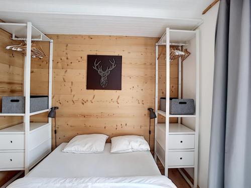 - une chambre avec 2 lits superposés et des étagères blanches dans l'établissement Montana - appartement - 6pers - proche centre, aux Gets