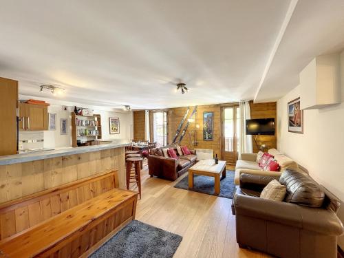 un salon avec un canapé et une cuisine dans l'établissement La Parisienne - appartement- 6pers- Centre, aux Gets