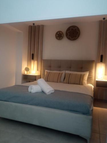 a bedroom with a large bed with two lamps at Rosemary Apartment in Exopoli, Georgioupolis in Exopoli