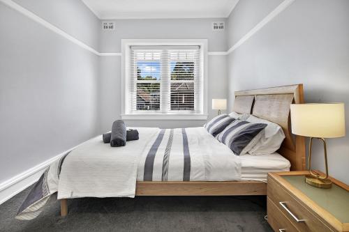 a bedroom with a bed and a window at Stylish, Sunny & Spacious 2 Bedroom Apartment, Mosman in Sydney