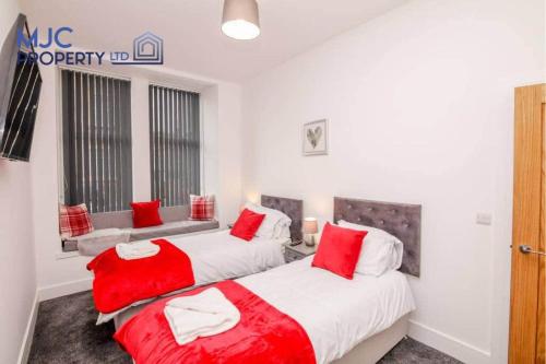duas camas num quarto com lençóis vermelhos e brancos em Mansfield em Hawick