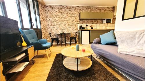 un salon avec un canapé et une table dans l'établissement L'industriel - Tout confort, à Saint-Brieuc