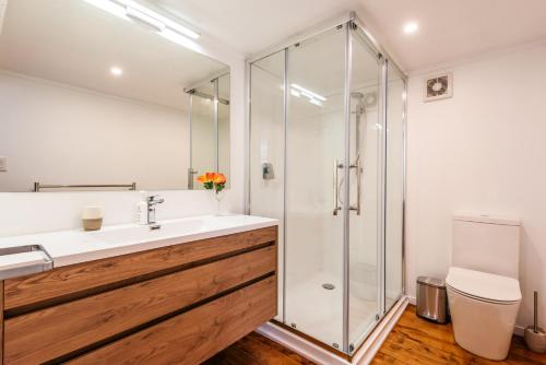 een badkamer met een wastafel en een douche bij Kina Cottage - Waiheke Island Holiday Home in Surfdale