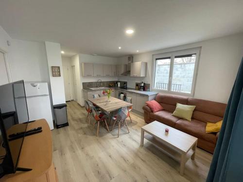 un salon avec un canapé et une table dans l'établissement Appartement T3 avec jardin et véranda, à Saint-Priest