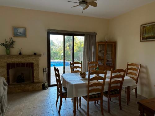 a dining room with a table and chairs and a fireplace at Seaview Villa Daria in Neo Chorio