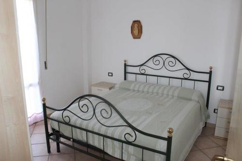 a bed in a bedroom with a white wall at trilocale 100 mt mare con terrazza abitabile in Marcelli
