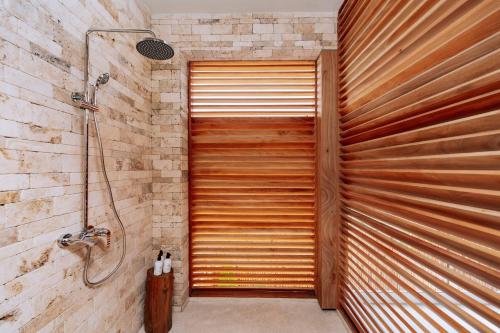 a wooden garage door in a bathroom with a shower at Samawa Living in Paje