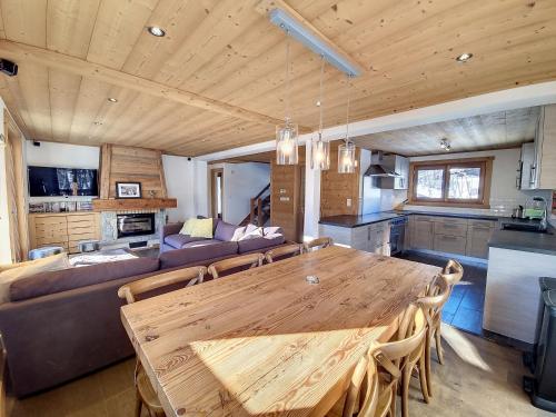 - une salle à manger et un salon avec une table en bois dans l'établissement Chalet Framboisiere - 10 pers - proche piste, aux Gets
