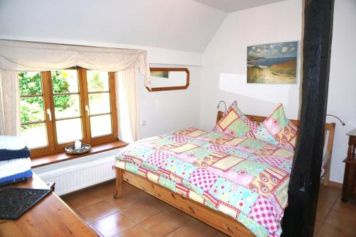 a bedroom with a bed in a room with windows at Altes Landhaus Oste, Klavier Appartement, 2 Zimmer mit Kamin in Hemmoor