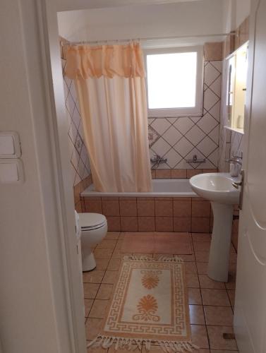 a bathroom with a tub and a toilet and a sink at Lina's House Pramanta in Pramanta