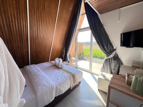ein Schlafzimmer mit einem Bett und einem großen Fenster in der Unterkunft Nalai View Cafe'&Restaurant/Homestay in Ban Lai Nan
