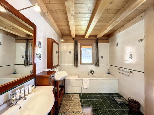 La salle de bains est pourvue de 2 lavabos, d'une baignoire et d'une baignoire. dans l'établissement Chalet 4 Saisons - 10pers - proche piste, aux Gets