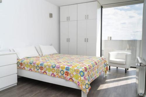a bedroom with a bed and a chair and a window at Moderna Villa con piscina en Palma de Mallorca in Palma de Mallorca
