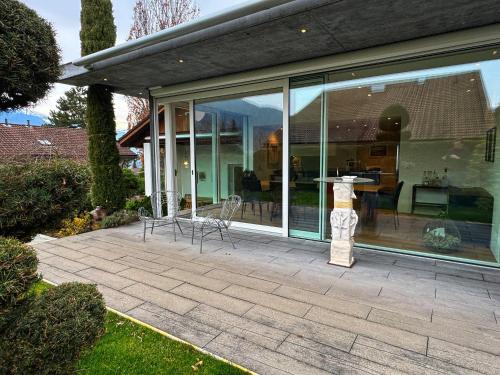 a house with glass windows and a statue on a patio at Casa Casparis in Maienfeld