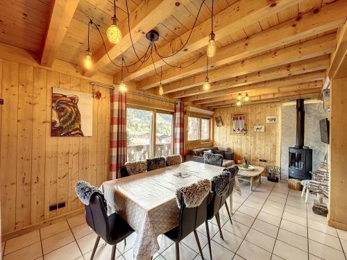une salle à manger avec une table et une cheminée dans l'établissement Chalet Olympiades -8 pers - proche centre, aux Gets