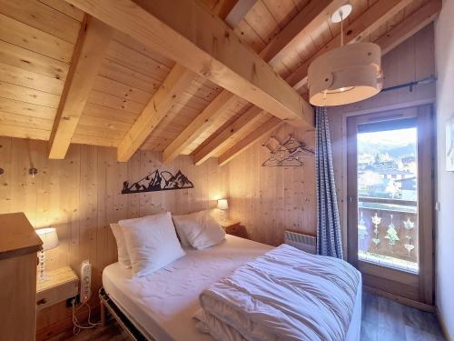une chambre avec un lit dans une pièce en bois dans l'établissement Chalet Olympiades -8 pers - proche centre, aux Gets