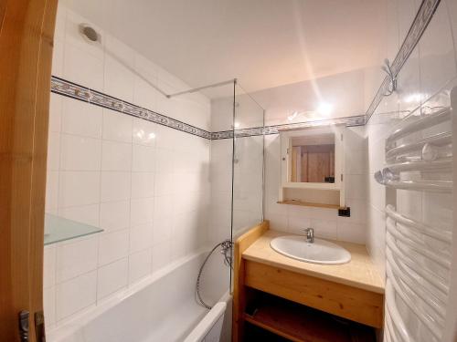une salle de bain avec un lavabo et une baignoire dans l'établissement Chalet Olympiades -8 pers - proche centre, aux Gets