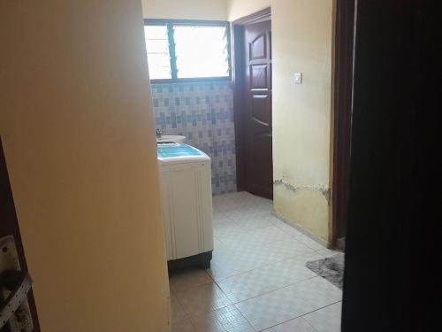 a bathroom with a sink and a window at Jay's Apt in Takoradi