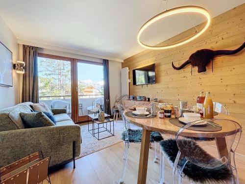 - un salon avec une table et un grand miroir dans l'établissement Les 3 Sapins - appartement- 4pers - centre station, aux Gets