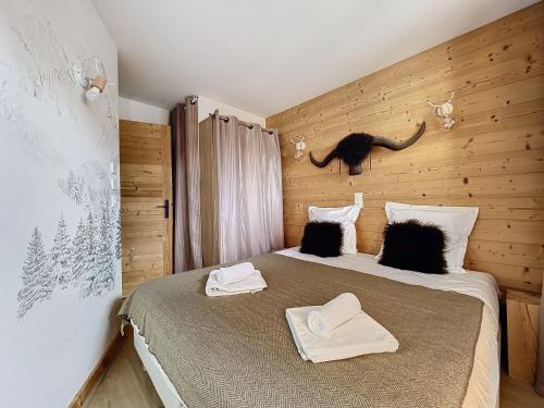 une chambre avec un lit avec deux serviettes dessus dans l'établissement Les 3 Sapins - appartement- 4pers - centre station, aux Gets