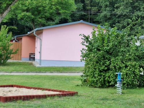 un edificio rosa con una boca de incendios en un patio en Terraced house in the nature and holiday park at the Gro Labenzer See, en Klein Labenz
