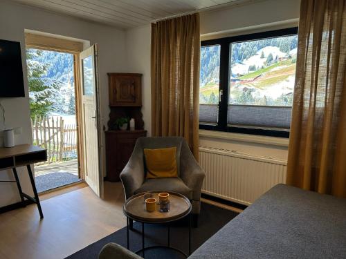a living room with a chair and a table and a window at Chalet 1480 in Gaschurn