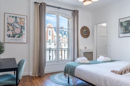 1 dormitorio con cama y ventana grande en Lavie Maison Grandeur Apartment, en Neuilly-sur-Seine