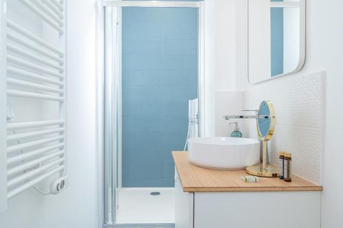 y baño blanco con lavabo y ducha. en Lavie Maison Grandeur Apartment, en Neuilly-sur-Seine