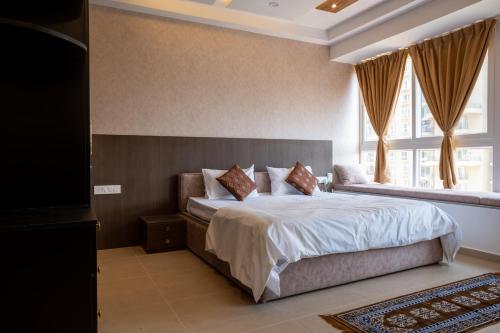 a bedroom with a large bed with a large window at Elegance Retreat in Yelahanka