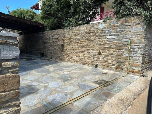 a stone retaining wall with a stone patio at Beachfront House Kipri in Kypri
