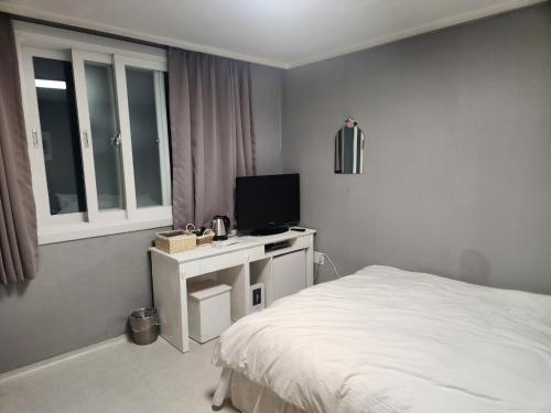 una camera con un letto e una televisione su un tavolo di Stay Mido a Busan