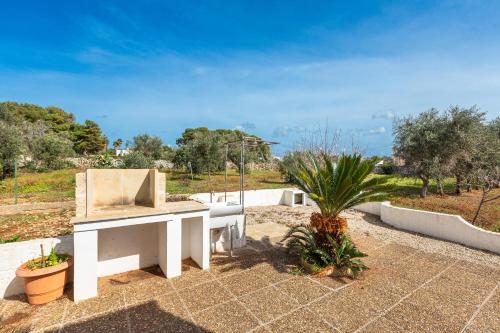 a white bench sitting on a patio with a plant at Salentoandmore - Villetta Anna in Marina di Pescoluse