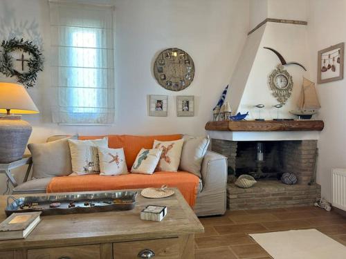 an orange couch in a living room with a fireplace at Beachfront House Kipri in Kypri