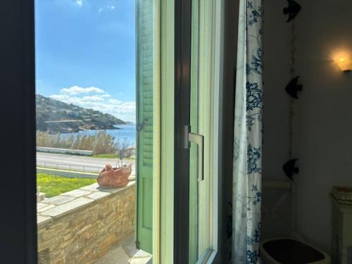 a door to a window with a view of the ocean at Beachfront House Kipri in Kypri