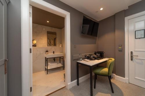 a bathroom with a desk and a sink and a shower at The Scott in Edinburgh