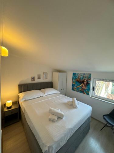 Un dormitorio con una cama grande con toallas. en San Marco Makarska, en Makarska