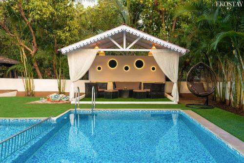 a house with a swimming pool in a yard at EKOSTAY Gold - CASA PORTO Villa in Anjuna