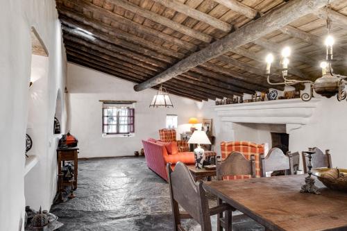 a living room with a table and a couch at Monte das Acácias in Santo António do Baldio