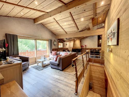 Elle comprend un grand salon doté de plafonds en bois et d'un canapé. dans l'établissement Chez Louis-appartement-8pers-proche piste, aux Gets