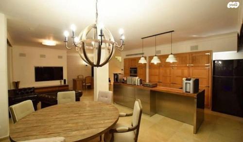 a dining room and kitchen with a wooden table and chairs at Fishman place in Herzliyya B