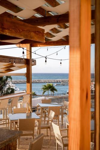 a view of the beach from a restaurant with tables and chairs at Cofresi Hills Residence in Gurapito