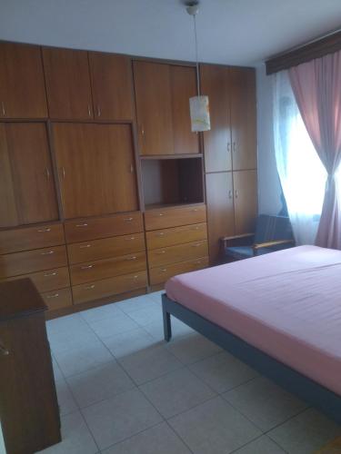 AGAPI'S HOUSE في سيديروكاسترو: غرفة نوم بسرير وبعض الدواليب الخشبية