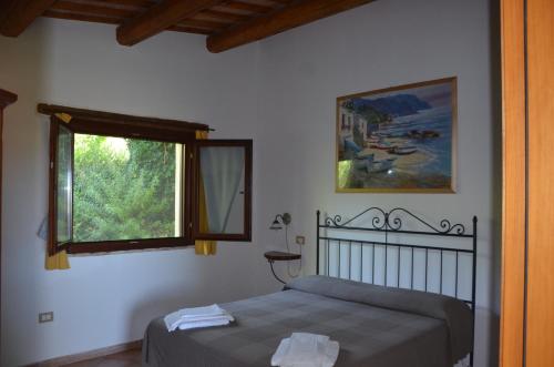 1 dormitorio con cama y ventana en agriturismo contrada del raglio en Potenza Picena