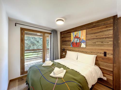 - une chambre avec un lit et un mur en bois dans l'établissement Solaret - appartement- 4pers- Proche Centre, aux Gets