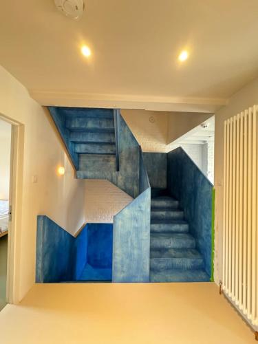 a staircase in a house with blue stairs at Beautifully Designed 4BD House Peckham London! in London