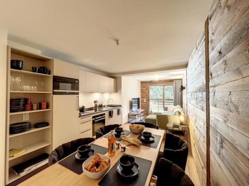 une cuisine avec une table et des chaises dans une pièce dans l'établissement Solaret - appartement- 4pers- Proche Centre, aux Gets