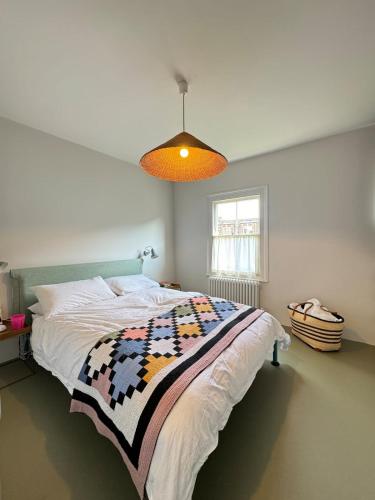 a bedroom with a bed with a quilt on it at Beautifully Designed 4BD House Peckham London! in London