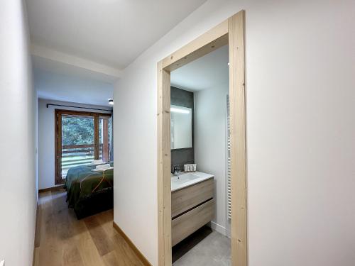 1 dormitorio con baño con lavabo y espejo en Solaret - appartement- 4pers- Proche Centre, en Les Gets